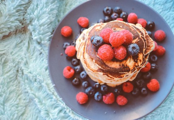 Beerenfrüchte mit Pfannkuchen Teller mit Beeren und Pfannkuchen